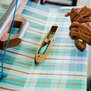 Handmade Thai fabric, cotton weaved loom machine with hand, close up textiles texture details